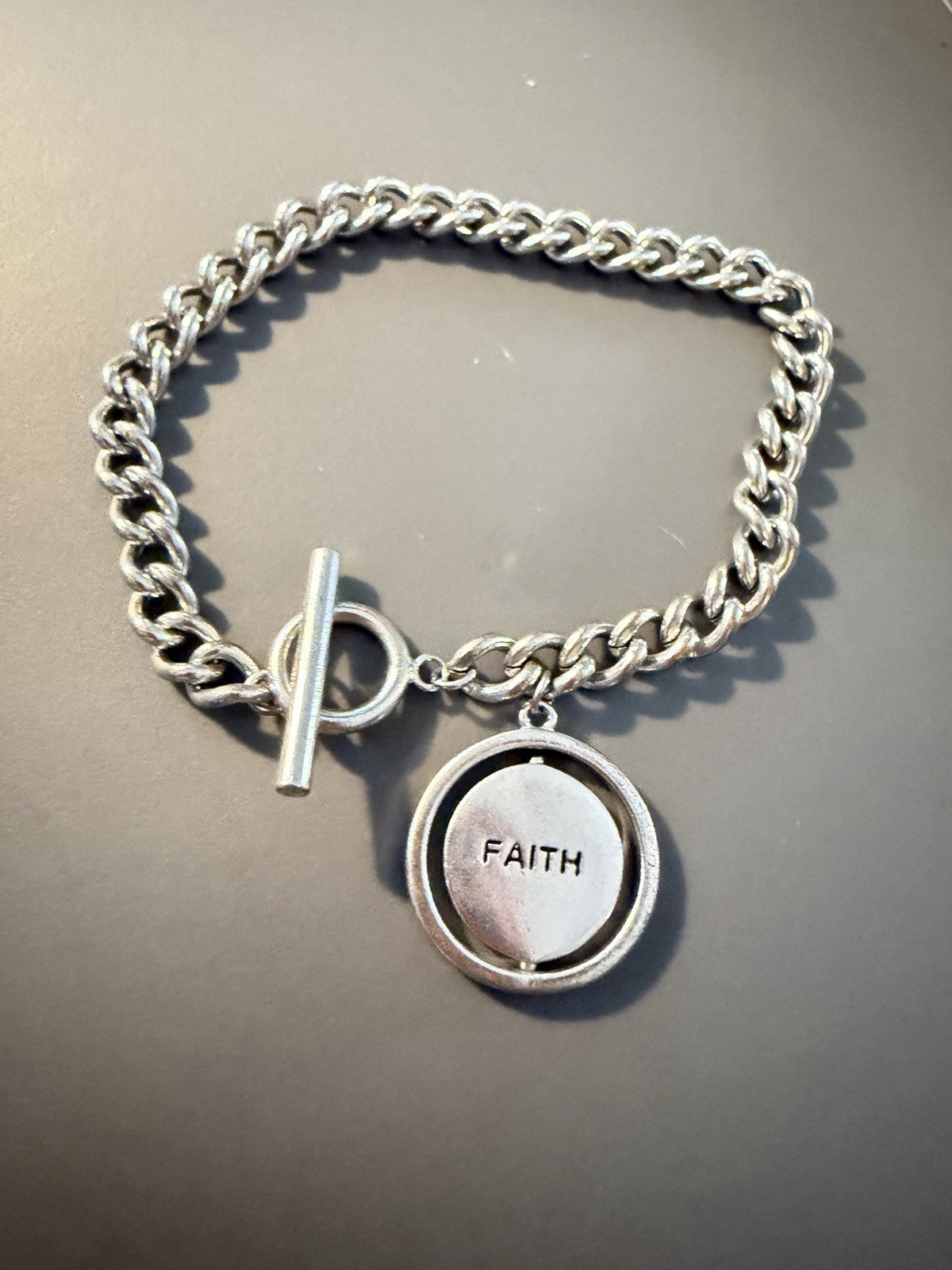 Silver Toned Toggle Bracelet Chain With Cross And Faith Spinner Pendant Tag