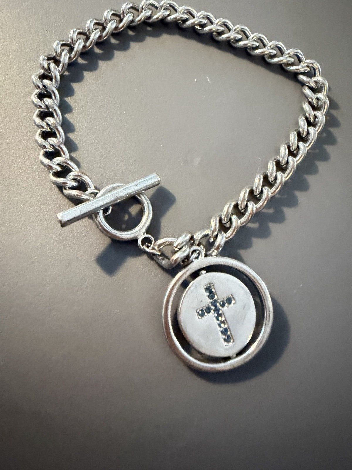 Silver Toned Toggle Bracelet Chain With Cross And Faith Spinner Pendant Tag